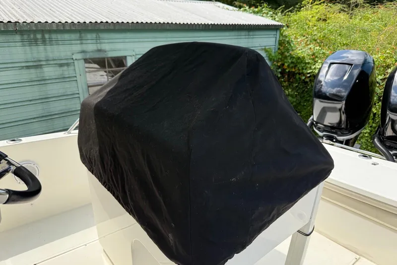 Slide: The Image of 2017 Boston Whaler 270 Dauntless console covered, with dual outboard motors visible. - 14