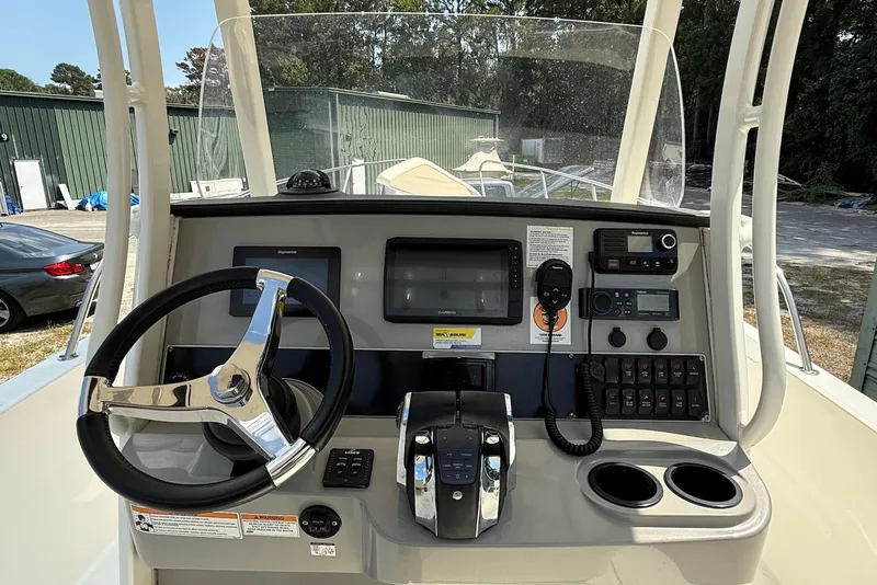 Slide: The Image of 2017 Boston Whaler 270 Dauntless helm with steering wheel, controls, and navigation equipment. - 2