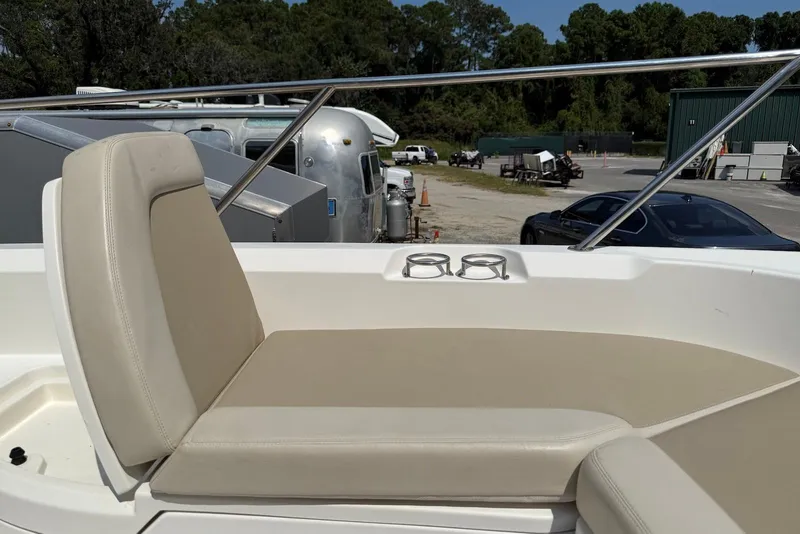 Slide: The Image of 2017 Boston Whaler 270 Dauntless boat seating area with cup holders, parked outdoors. - 6