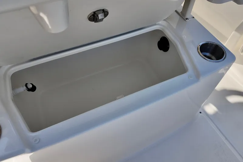 Slide: The Image of 2026 Bayliner Trophy T22CC boat storage compartment with cup holder, open lid view. - 13