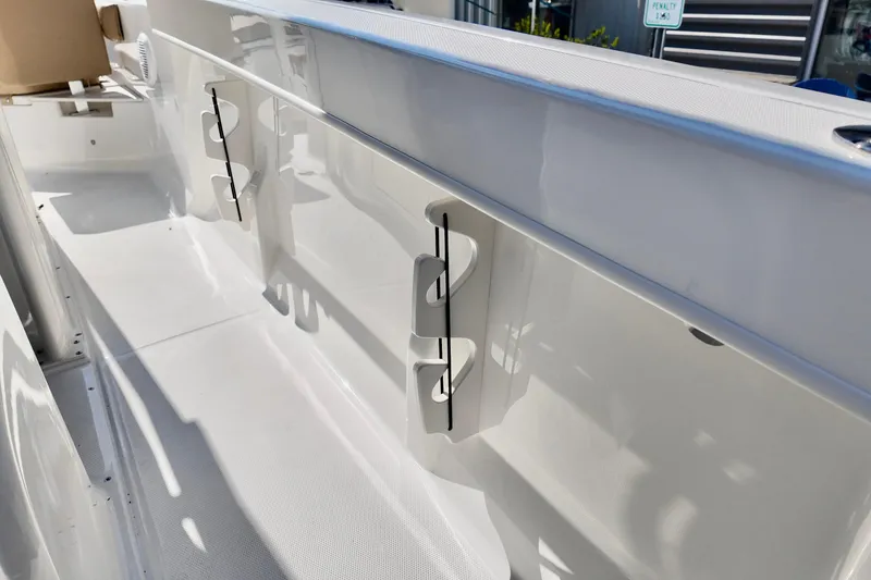 Slide: The Image of 2026 Bayliner Trophy T22CC boat interior with rod holders and sleek white finish. - 14