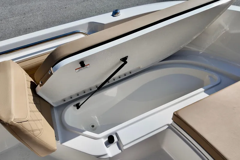 Slide: The Image of 2026 Bayliner Trophy T22CC boat with open storage compartment and cushioned seating. - 17