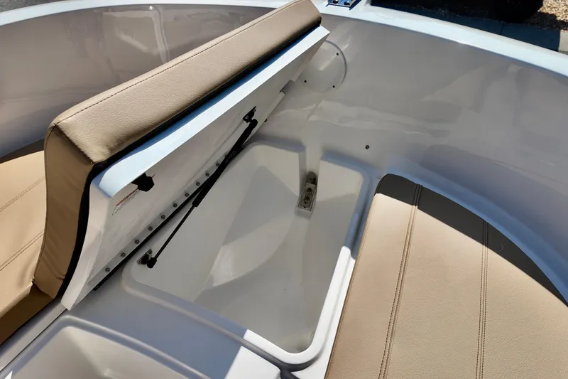 Slide: The Image of 2026 Bayliner Trophy T22CC boat interior with open storage compartment and beige seating. - 18