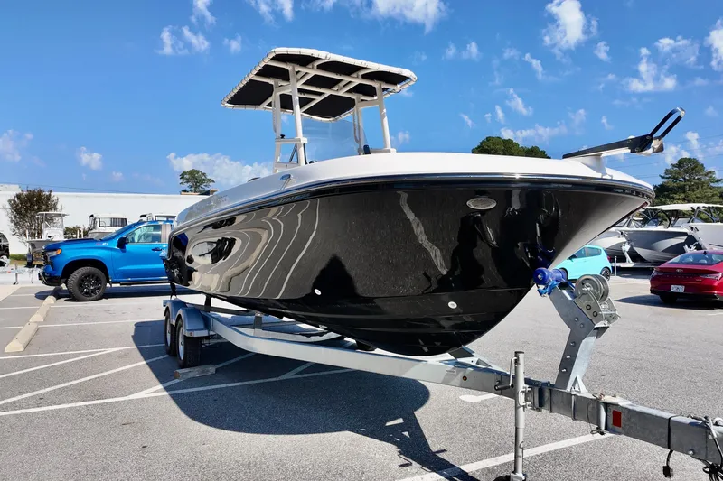 Slide: The Image of 2026 Bayliner Trophy T22CC boat on trailer in parking lot under blue sky. - 3