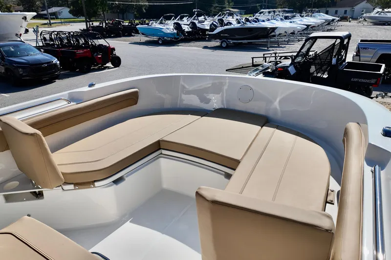 Slide: The Image of 2026 Bayliner Trophy T22CC boat with beige seating, displayed at a dealership. - 5