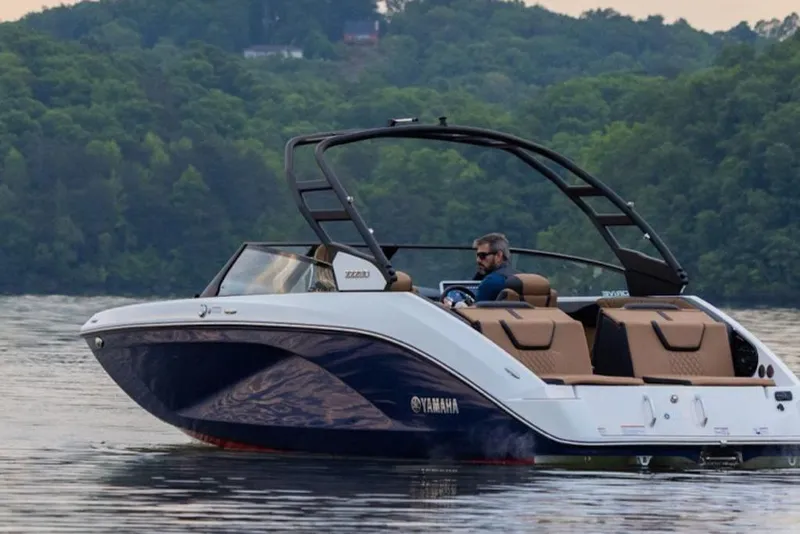 Slide: The Image of 2026 Yamaha Boats 222SE cruising on a serene lake with lush green forest backdrop. - 4