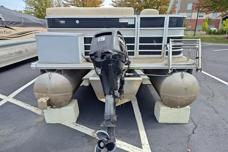 Slide: The Image of 2019 Sylvan 818 Mirage Cruise pontoon boat with Mercury outboard motor in a parking lot. - 2