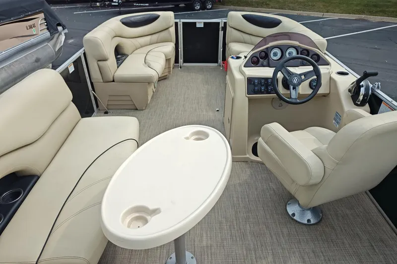 Slide: The Image of 2019 Sylvan 818 Mirage Cruise boat interior with beige seating and steering console. - 3
