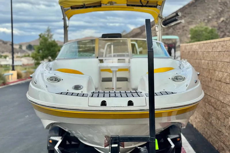 Slide: The Image of 2005 MB 240 V Sportdeck boat with yellow accents on a trailer, outdoor setting. - 2