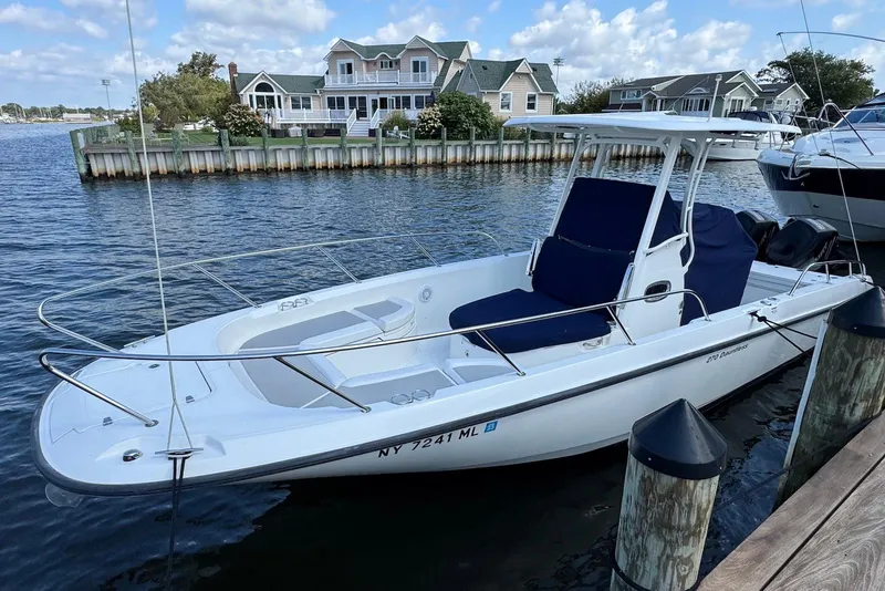 Slide: The Image of 2015 Boston Whaler 270 Dauntless boat docked by waterfront homes. - 3