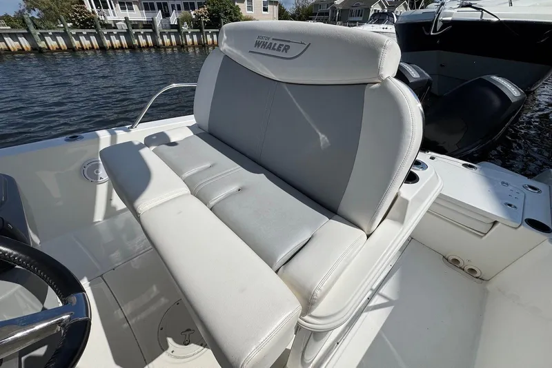 Slide: The Image of 2015 Boston Whaler 270 Dauntless boat seat, white leather, docked by waterfront homes. - 4