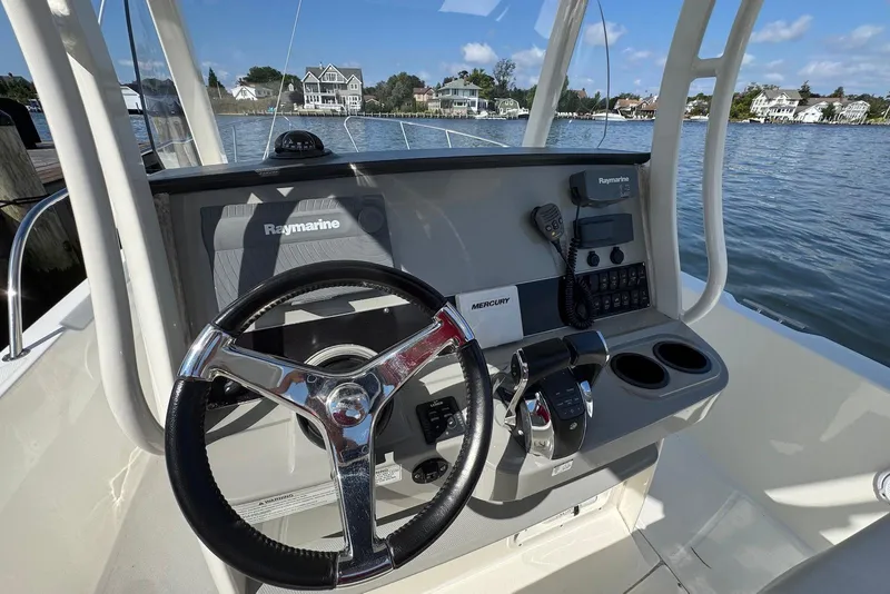Slide: The Image of Helm of 2015 Boston Whaler 270 Dauntless with Raymarine electronics, steering wheel, and controls. - 5