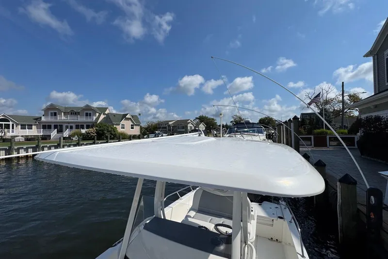 Slide: The Image of 2015 Boston Whaler 270 Dauntless docked near waterfront homes under a clear blue sky. - 6