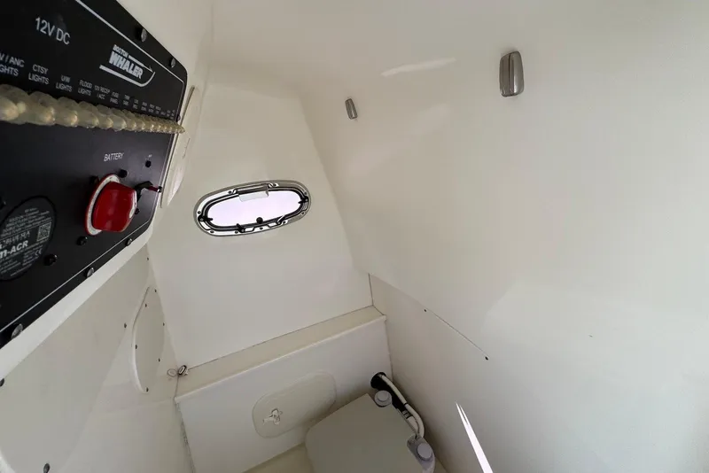 Slide: The Image of Interior of 2015 Boston Whaler 270 Dauntless boat, featuring control panel and small window. - 8