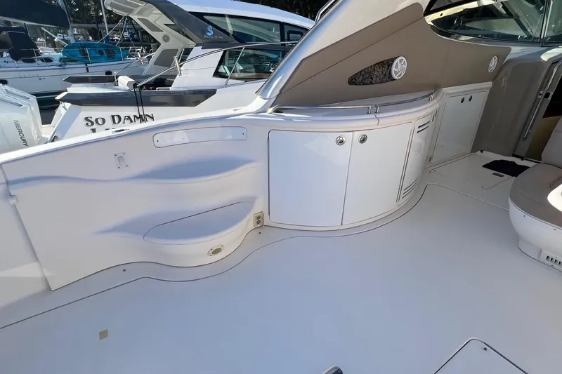 Slide: The Image of 1998 Sea Ray 540 Sundancer yacht interior with sleek white cabinetry and seating area. - 10