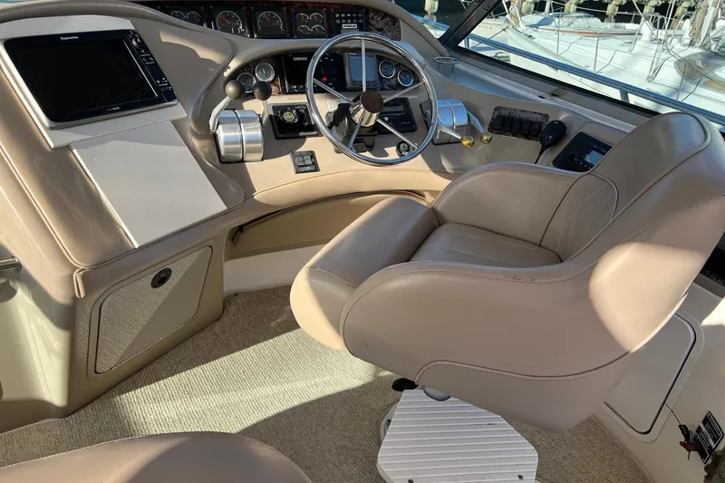Slide: The Image of 1998 Sea Ray 540 Sundancer helm with beige leather seat and modern controls. - 19