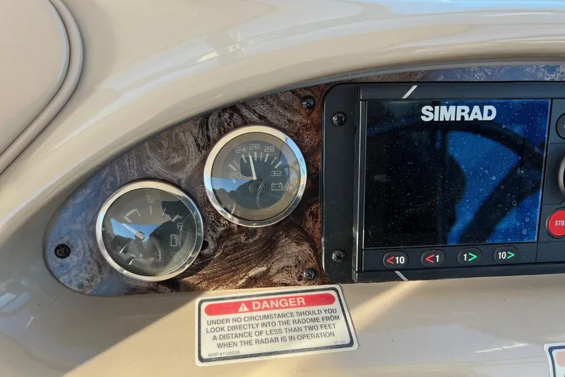 Slide: The Image of Dashboard of a 1998 Sea Ray 540 Sundancer with gauges and Simrad display. - 23