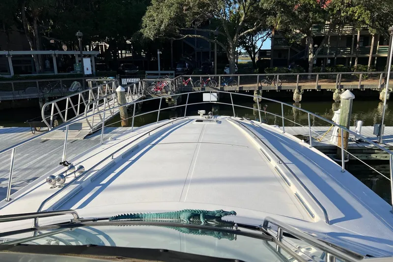 Slide: The Image of 1998 Sea Ray 540 Sundancer yacht docked at a marina with scenic surroundings. - 3