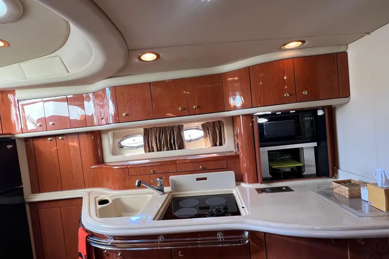 Slide: The Image of Luxurious kitchen interior of 1998 Sea Ray 540 Sundancer yacht with wood cabinetry and modern appliances. - 38