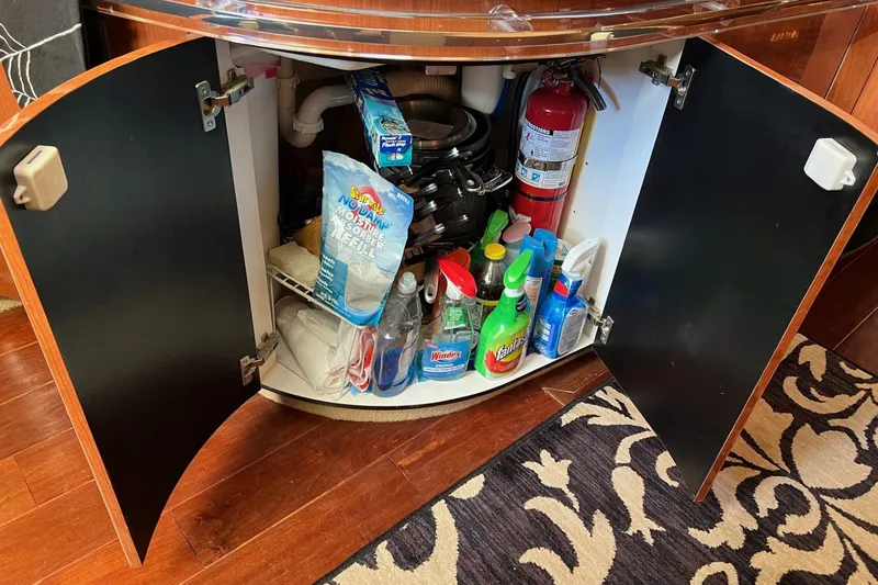 Slide: The Image of Open cabinet on 1998 Sea Ray 540 Sundancer with cleaning supplies and fire extinguisher. - 39
