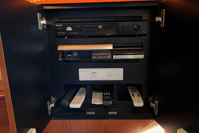 Slide: The Image of Entertainment system cabinet on 1998 Sea Ray 540 Sundancer yacht with DVD player and remotes. - 58