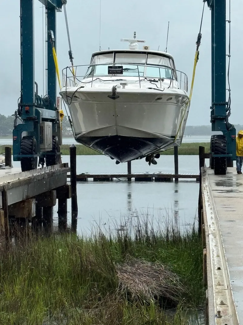 Slide: The Image of 1998 Sea Ray 540 Sundancer yacht being lifted by a crane at a marina. - 83