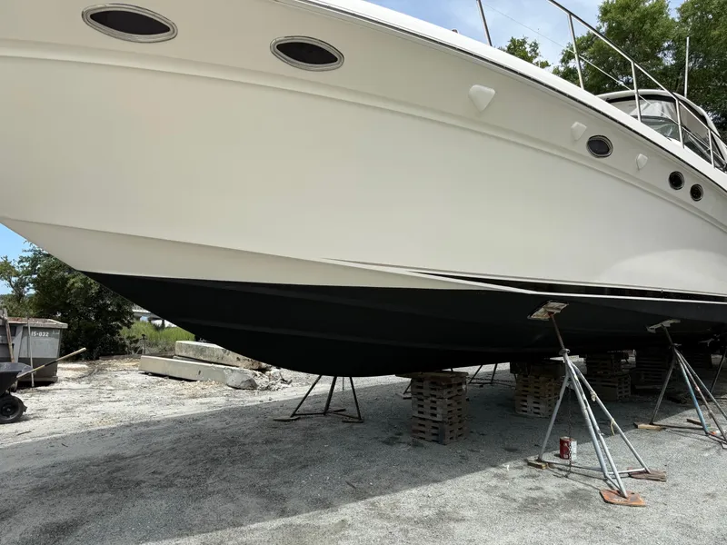 Slide: The Image of 1998 Sea Ray 540 Sundancer yacht on dry dock, supported by stands. - 87