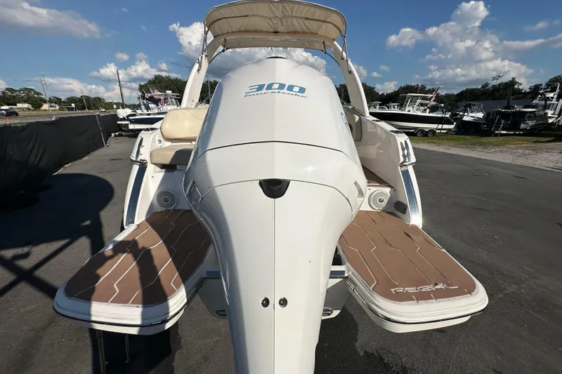 Slide: The Image of 2019 Regal 26 OBX boat with outboard motor and swim platforms, docked outdoors. - 12