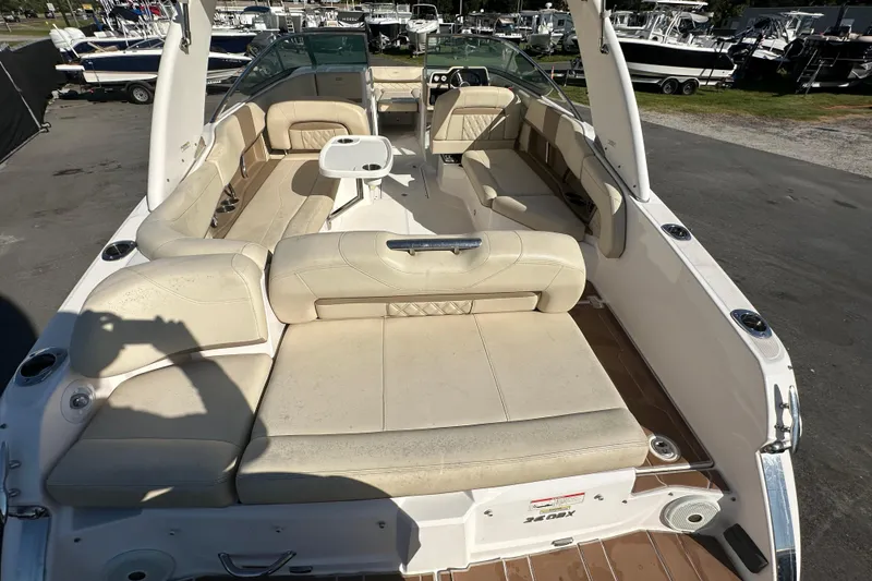 Slide: The Image of 2019 Regal 26 OBX boat interior with beige seating and table, docked outdoors. - 19
