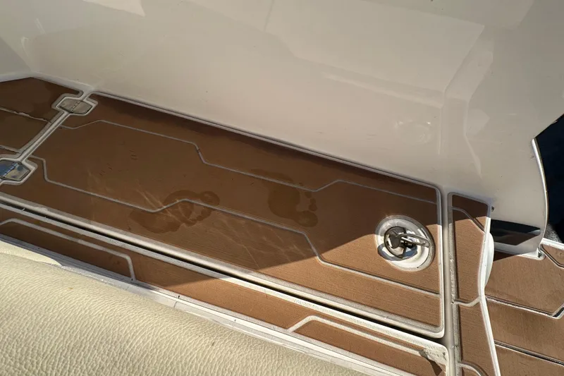 Slide: The Image of 2019 Regal 26 OBX boat deck with wet footprints and a metal fixture. - 23