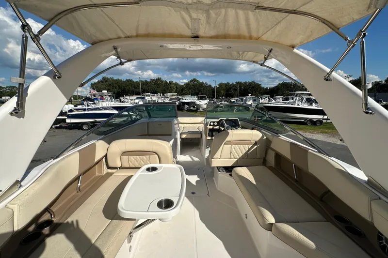Slide: The Image of 2019 Regal 26 OBX boat interior with beige seating and canopy, docked at marina. - 26