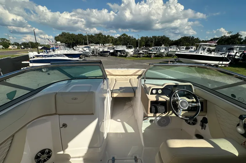 Slide: The Image of 2019 Regal 26 OBX boat interior with steering wheel, dashboard, and seating under a blue sky. - 29