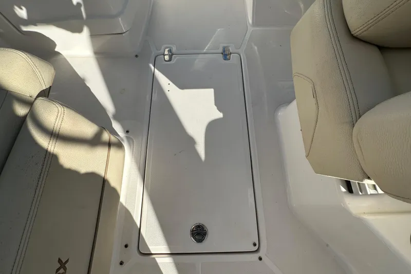 Slide: The Image of 2019 Regal 26 OBX boat interior with beige seating and storage compartment. - 31