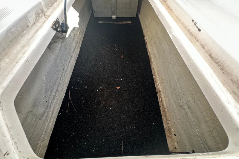 Slide: The Image of Storage compartment of a 2019 Regal 26 OBX boat, featuring a black non-slip surface. - 32
