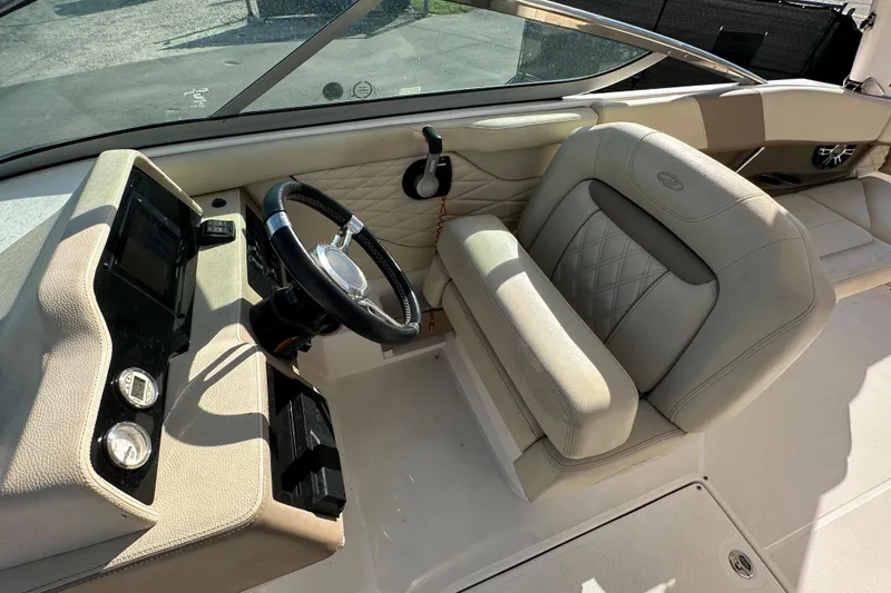 Slide: The Image of 2019 Regal 26 OBX boat interior with steering wheel and beige seating. - 40