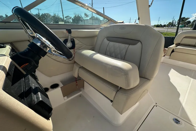 Slide: The Image of 2019 Regal 26 OBX boat interior with steering wheel and beige seating. - 41
