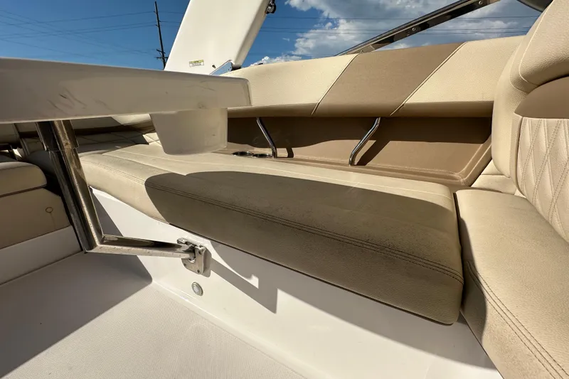 Slide: The Image of 2019 Regal 26 OBX boat interior with beige seating and stainless steel fixtures. - 53