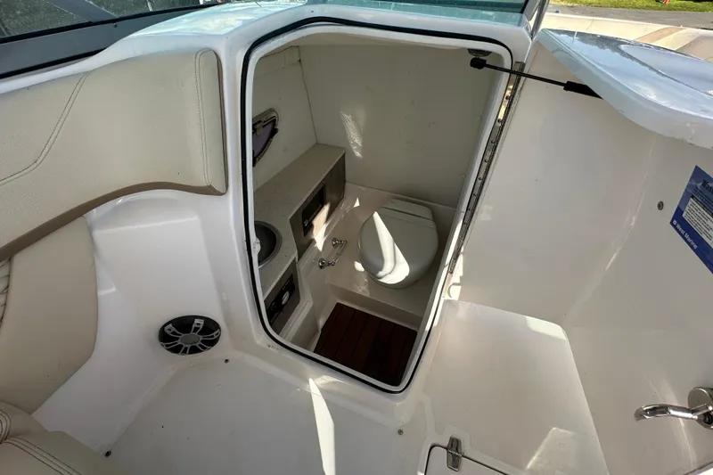 Slide: The Image of 2019 Regal 26 OBX boat interior with compact bathroom and seating area. - 60