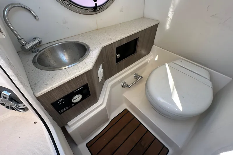 Slide: The Image of 2019 Regal 26 OBX boat bathroom with sink, toilet, and wooden floor. - 62