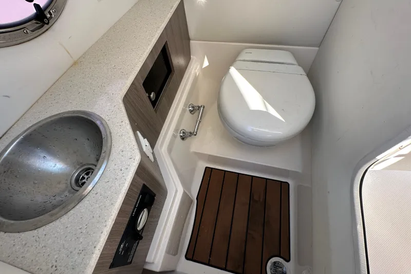Slide: The Image of 2019 Regal 26 OBX boat bathroom with sink, toilet, and wooden floor. - 63