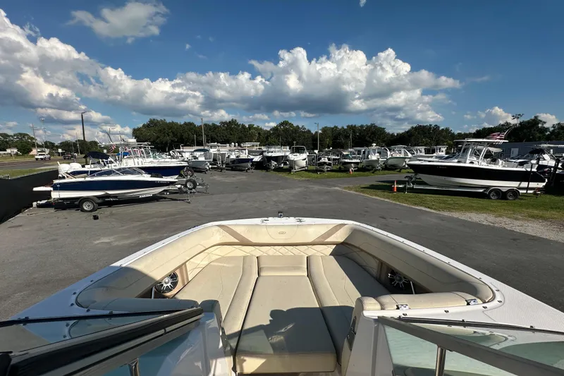Slide: The Image of 2019 Regal 26 OBX boat at a dealership, surrounded by other boats under a blue sky. - 64
