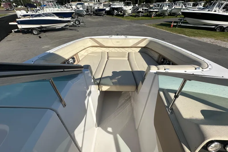 Slide: The Image of 2019 Regal 26 OBX boat interior with beige seating, docked among other boats. - 65