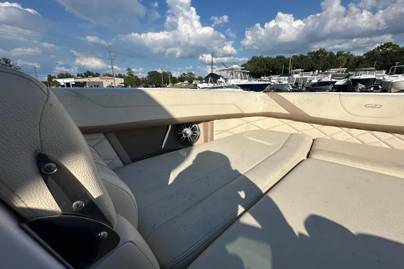 Slide: The Image of 2019 Regal 26 OBX boat interior with beige seating under a blue sky. - 68