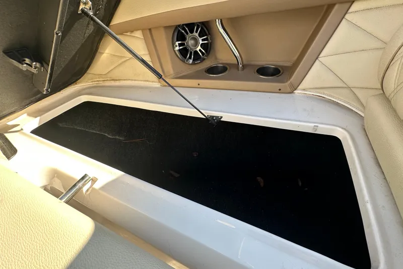 Slide: The Image of Open storage compartment in 2019 Regal 26 OBX boat, featuring cup holders and speaker. - 73