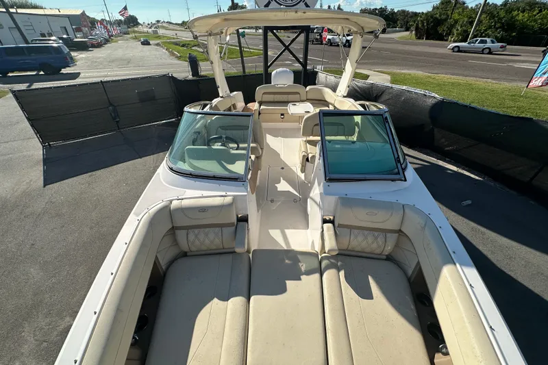 Slide: The Image of 2019 Regal 26 OBX boat with spacious seating and windshield, parked on a sunny day. - 77