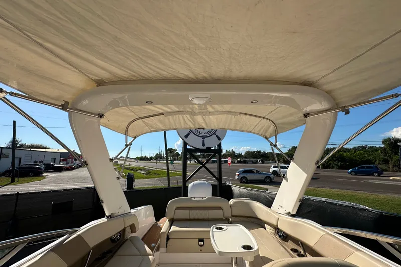 Slide: The Image of 2019 Regal 26 OBX boat interior with canopy, beige seating, and table. - 85