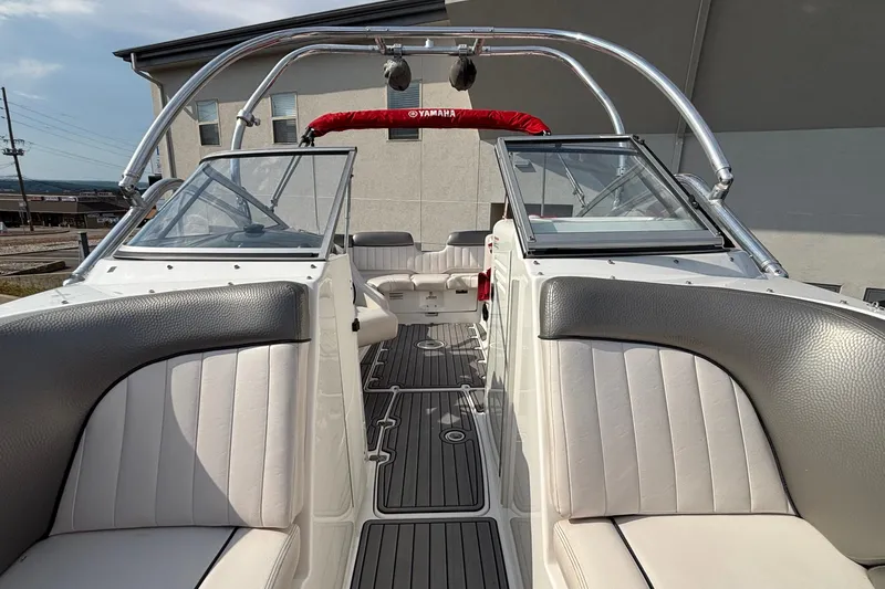 Slide: The Image of 2008 Yamaha Boats SX230 in red and white on a trailer, parked outdoors. - 7