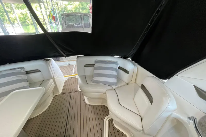 Slide: The Image of Interior of 2007 Sea Ray 38 Sundancer with white seating and striped cushions. - 13