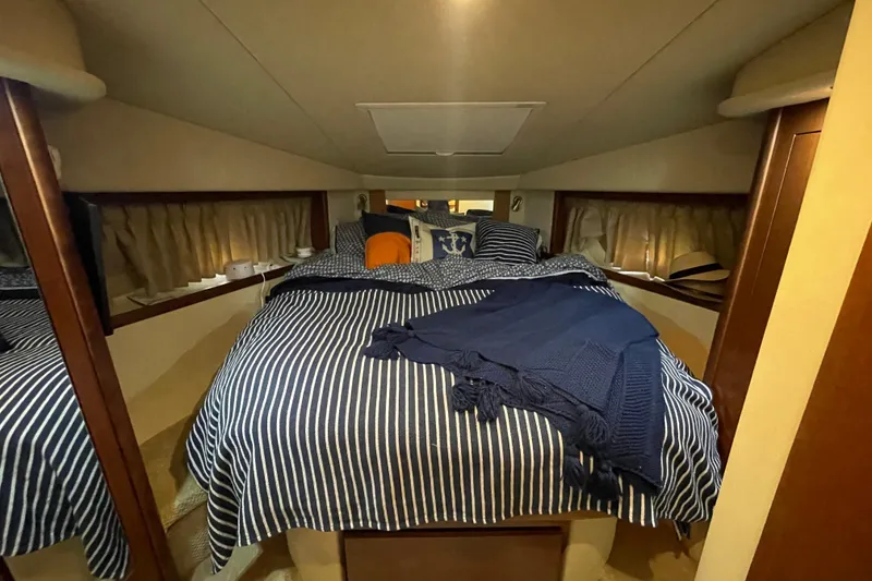 Slide: The Image of Cozy cabin interior of 2007 Sea Ray 38 Sundancer with striped bedding and nautical decor. - 22