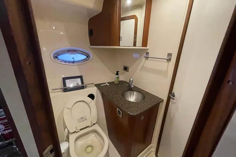 Slide: The Image of 2007 Sea Ray 38 Sundancer bathroom with sink, toilet, and porthole window. - 24